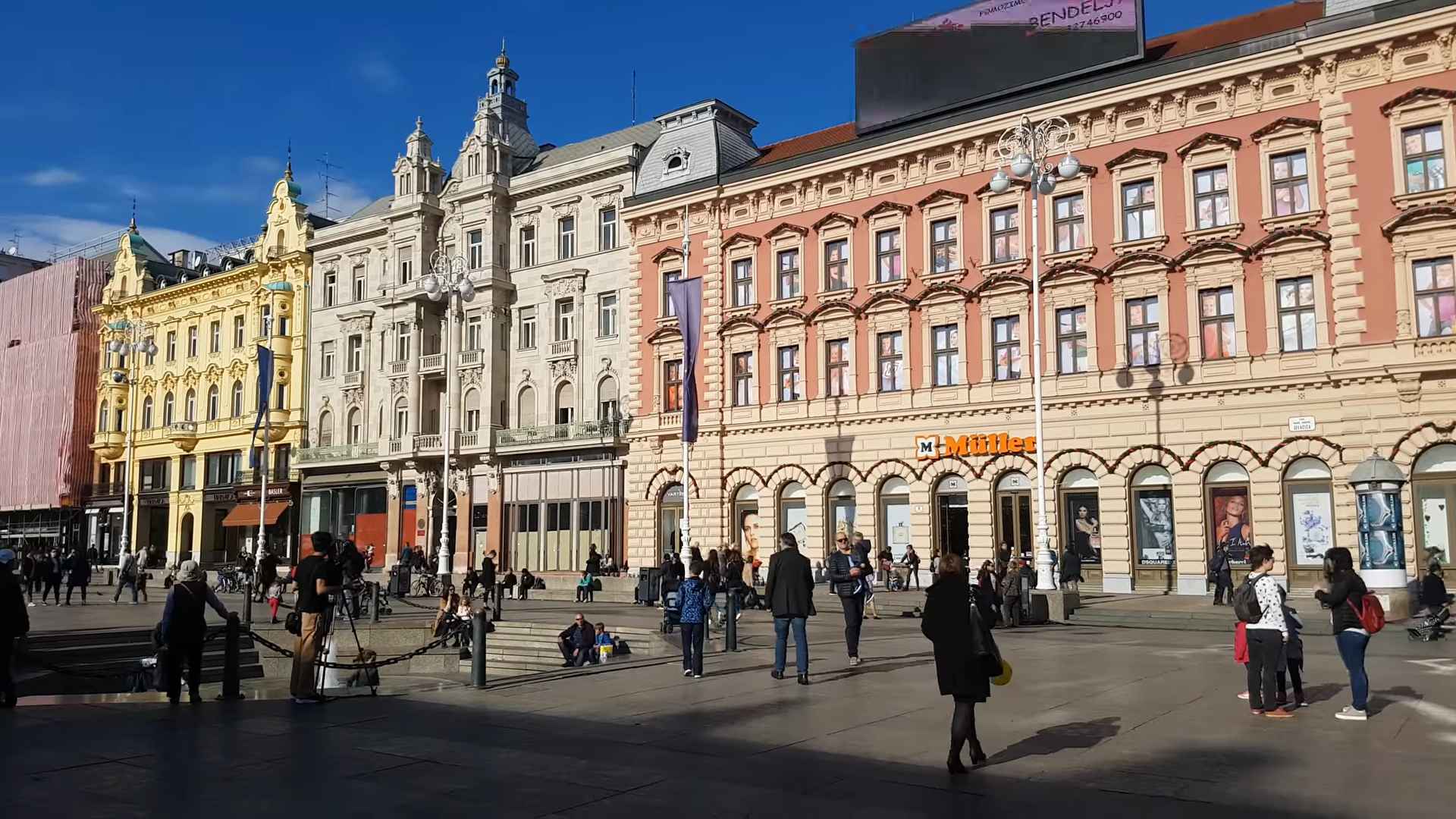 Trg bana Jelačića u Zagrebu sa istorijskim zgradama, prolaznicima i gradskom arhitekturom.